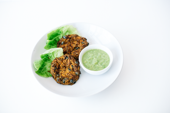 Black Bean & Sweet Potato Burgers product photo (2 shown with butter lettuce leaf cups and tomatillo avocado seasoning)